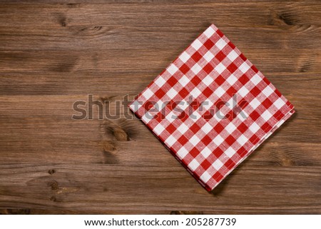 Folded red-white napkin on wooden table