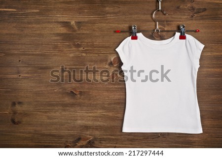 White T-shirt hanging on wooden background