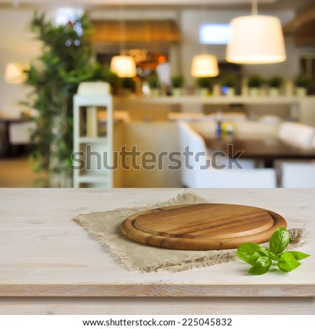 Cutting board on table over blurred restaurant interior background