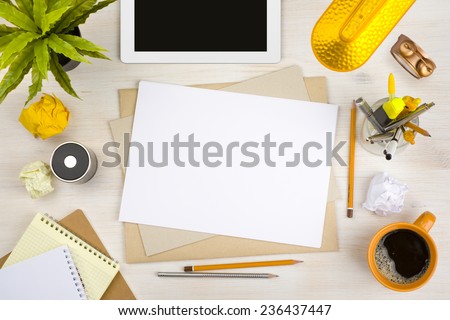 Top view of office desk with paper, stationery and tablet computer