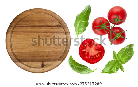 Top view of isolated cutting board with tomato and basil