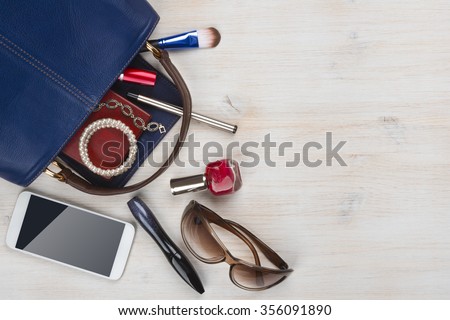 View on women bag stuff with copyspace on wooden background