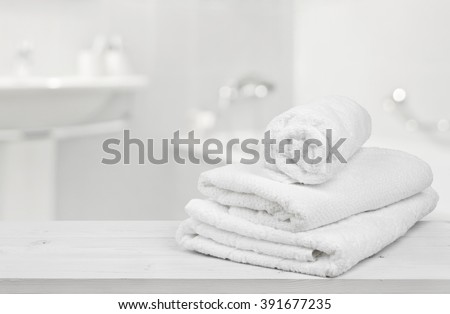 Stack of folded white towels over blurred bathroom background