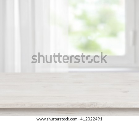 Wooden table surface on defocused half curtained window background