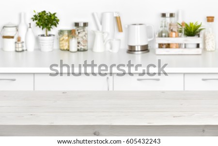 Wooden planks table over blurred image of kitchen bench interior