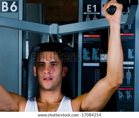 Bodybuilder male shoulders deltoids vest working out in gym on shoulder press
