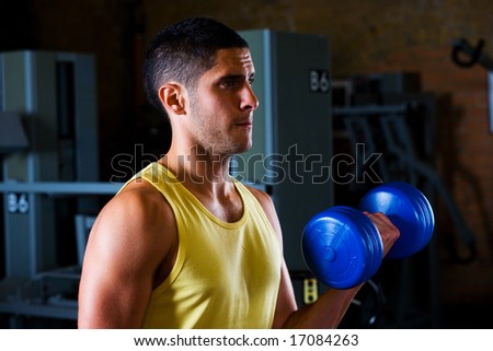 Bodybuilder male shoulders deltoids vest working out in gym with dumbells