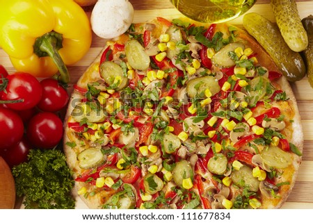 Pizza with pickles, corn, pepper and cheese and ingredients