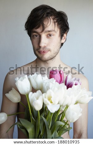 Portrait of young attractive man with flowers