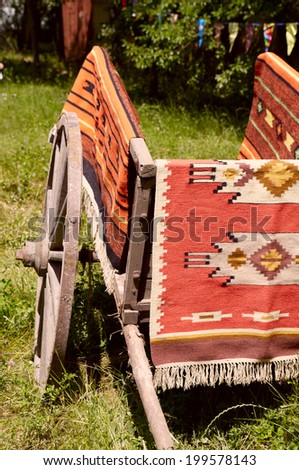 Ancient Romanian wooden cart standing on a green grass