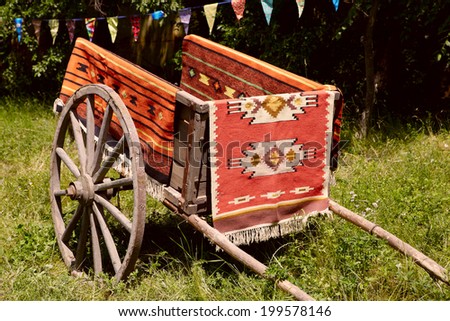 Ancient Romanian wooden cart standing on a green grass