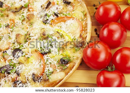 Pizza vegetarian with eggplant, olives, tomatoes, parmesan and sweet pepper