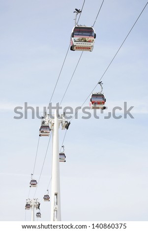 LONDON - MAY 26: Gondolas of the Emirates Air Line cable car, opened June 2012, run by TFL, links the Greenwich Peninsula with Royal Dock, 1km, across the River Thames on 26 May, 2013.