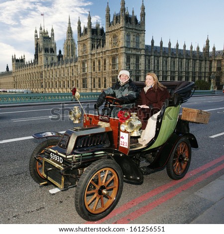 LONDON - NOV 03: London to Brighton Veteran Car Run participants passing Westminster Bridge, Westminster Palace in background, on Nov 3, 2013 in London, UK. Event starts at 7:00am in Hyde Park, London
