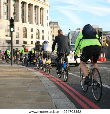 Bicycle commuters on their way to work after crossing Blackfriars bridge in early morning.