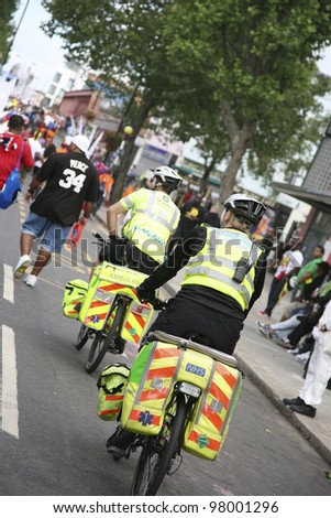 LONDON - AUG 30 : St John Ambulance aiders, bicycles allow to move more quickly through crowds with medical equipment, are ready to help patients at Notthing Hill Carnival on Aug 30, 2010, London, UK