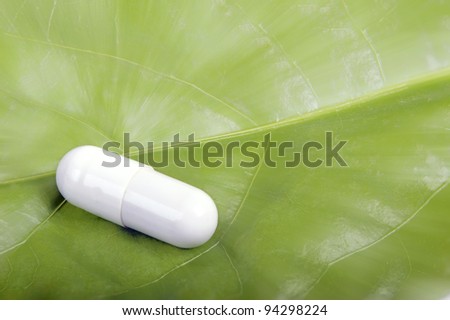 Capsule from a vegetative medical product on green sheet
