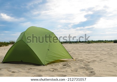pitched tent in the desert on sunny day - stock photo