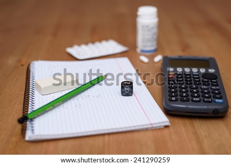 study place with calculator and painkillers in background - stock photo