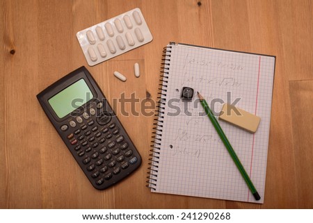 study place with calculator and painkillers in background - stock photo