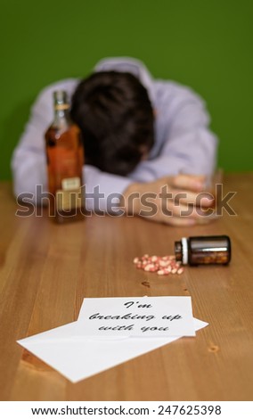 depressed male with alcohol and pills after reading break up letter