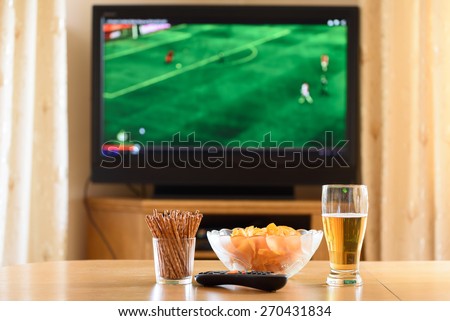 television, TV watching (football, soccer match) with snacks lying on table - stock photo