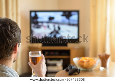 man playing war video game on console (television) in home - stock photo