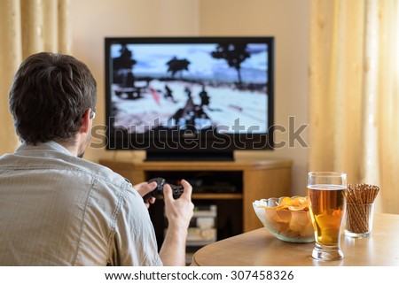 man playing war video game on console (television) in home - stock photo