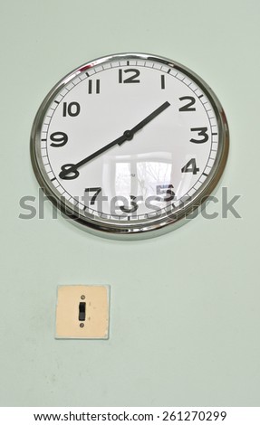 old electrical switch and a modern clock on the wall