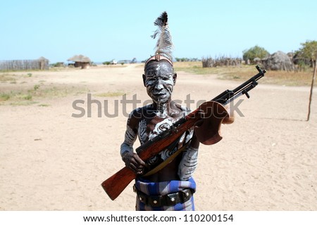 OMO VALLEY-JAN 25:Unidentified Karo Man with gun in his hand Jan 25, 2012 in Omo Valley, Ethiopia.The ethnic groups in the Omo valley could disappear because of Gibe III hydroelectric dam.
