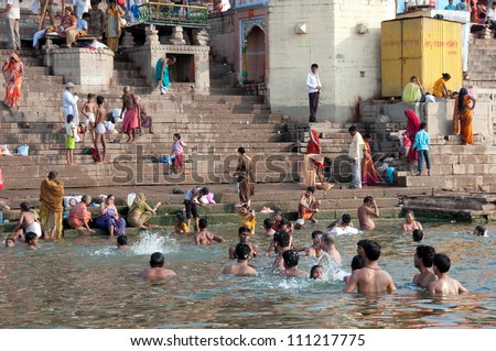 VARANASI, INDIA - MAY 15: An unidentified group of Indian people wash themselves in  river Ganga on MAY 15, 2012  in Varanasi, Central India. The holy ritual of washing is held every day.