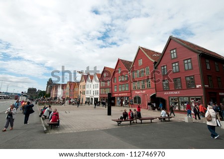 BERGEN, NORWAY - JUNE 15: Tourists and locals stroll along the UNESCO World Heritage Site, Bryggen, in the city of Bergen, on June 15, 2011. Bryggen is famous for its old wooden buildings and history.