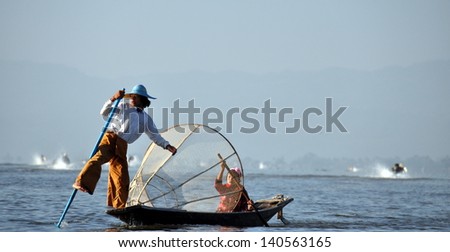 INLE LAKE, MYANMAR - FEBRUARY 17: Fisherman catches fish for food on February 17, 2012 on Inle Lake, Myanmar. Intha people possess the leg-rowing style and the unique coop-like fishing equipment