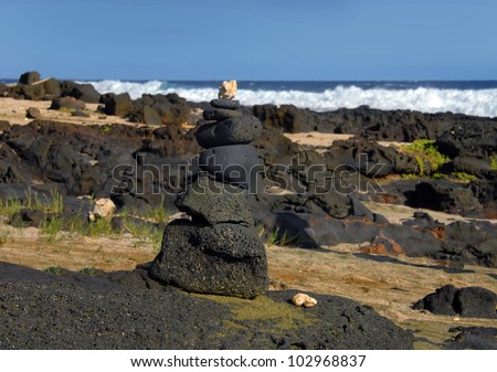 On the rugged shore of South Point, Big Island of Hawaii, locals have set up an alter of lava stone and coral.  Green sand called Olivine lays scattered across beach.
