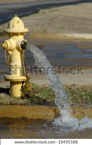 Water company opens valve in water hydrant for routine maintenance.  Water splashes onto street.