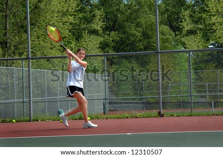 Ball is hit by tennis player.  Female teen runs to return volley during game.