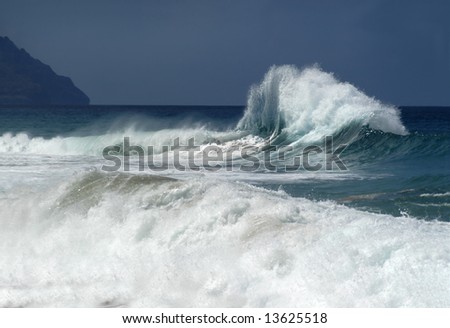 Angry waves great each other with flying spray and curling surf off the shores of Kauai, Hawaii.