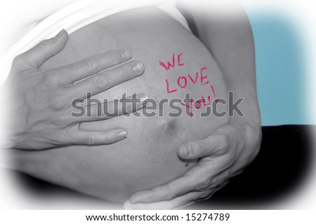 Expecting Mom cradles her tummy with both hands.  The words 