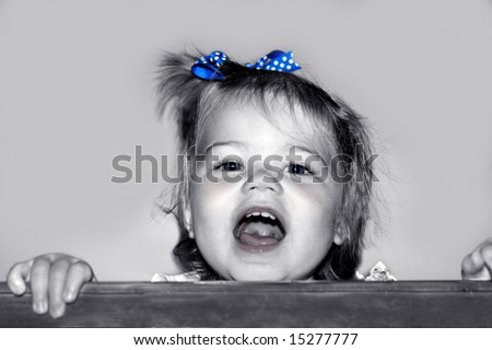Baby girl stands in crib and giggles, garbles and makes all those cute baby noises.  Black and white with color added.