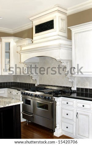 Beautiful white and black kitchen with painted wooden cabinets and wood flooring.