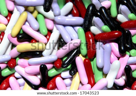 Background is filled with color coated licorice candy in fun colors of yellow, green, red and black.