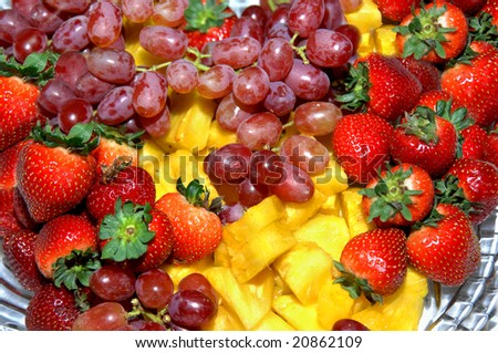 Fruit tray includes strawberries, grapes and pineapple.