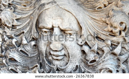 Face in stone wall has curling hair tendrils.  Eureka Springs, Arkansas