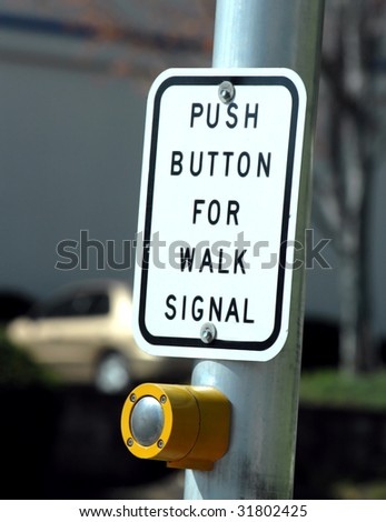 Button ready for pedestrian traffic.  Gold car is parked in background.