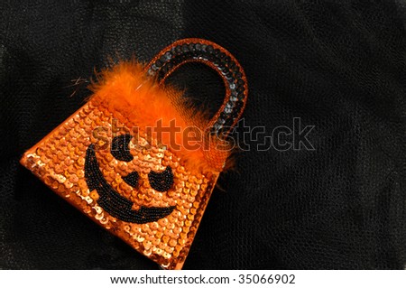 Halloween purse is covered with orange and black sequins.