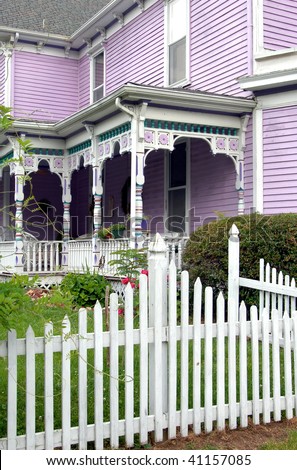 Lilac painted wood, flower shaped wood carvings, and turquoise spindles makes this victorian home elegant and eye catching.