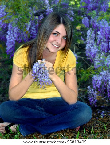 School uniforms | Teen Opinion Essay stock photo happy young female teen sits on the ground surrounded by wisteria blossoms she holds one grape 55813405 School uniforms | Teen Opinion Essay
