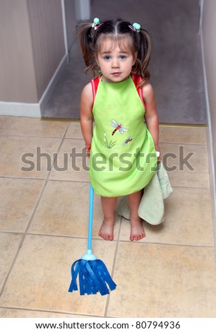 All hands on deck!  This little girl is ready and willing to help her mother with household chores.  She is wearing her apron, holding her dusting rag and wielding her mop.