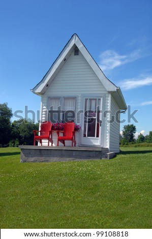 Cottage has bright red chairs to match its red door.  Small compact lodging outside of Kingston, Ontario, Canada.