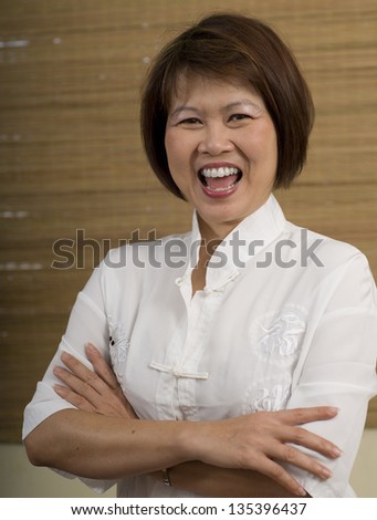 Happy mature Asian woman laughing